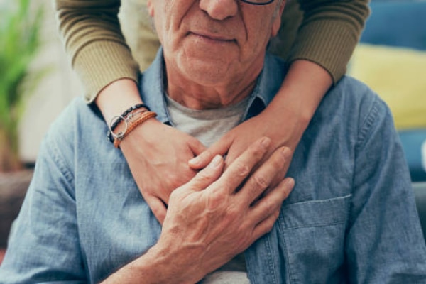 Older man with daughters hand holding him