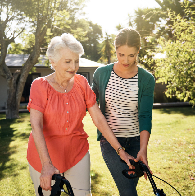 Daughter helping mother using walker