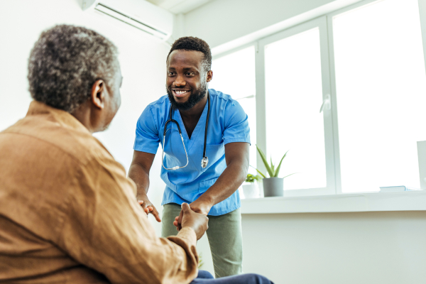 Male nurse greeting patient in wheelchair