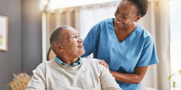 Female nurse leaning over patient smiling